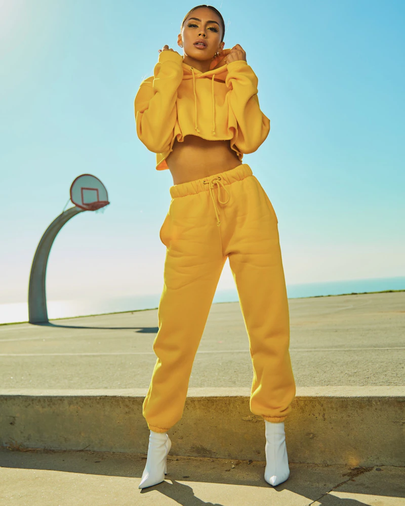 Woman in a yellow tracksuit on a sunny court