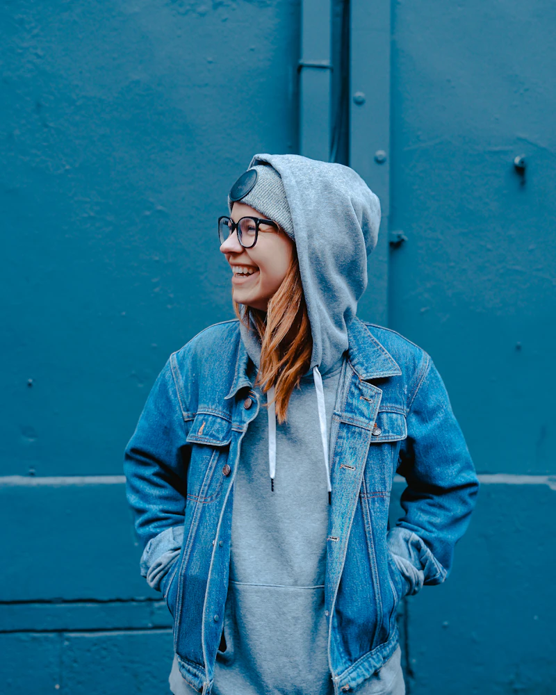 Woman in a denim jacket over a grey hoodie